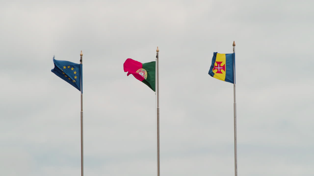 Flags Of EU, Portugal And Madeira Island Swaying At Gentle Breeze. medium shot