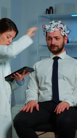 doctor performing eeg brain activity scan on patient in laboratory
