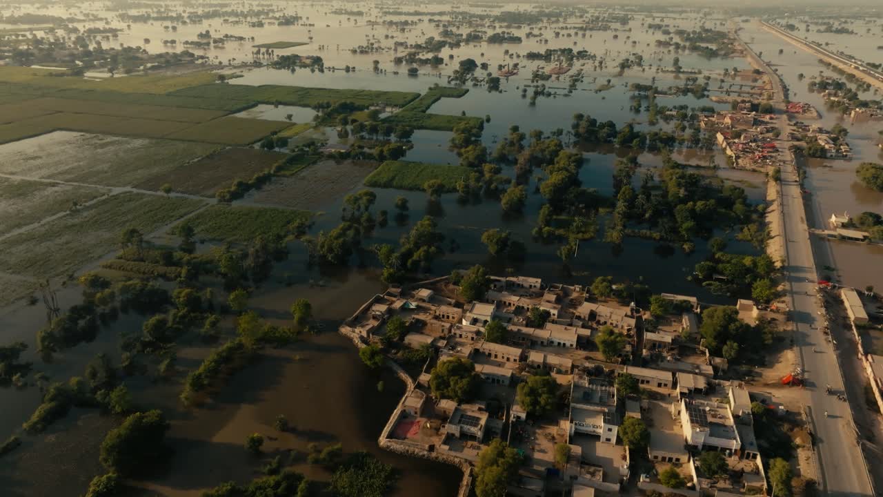 Widespread floodwaters inundating rural villages, fields, and a road in Punjab, Pakistan