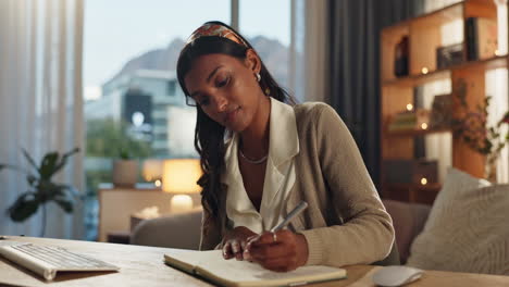 woman writing in a notebook at her desk