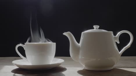 the hot tea in the white cup has white smoke and steam effect on the black background.