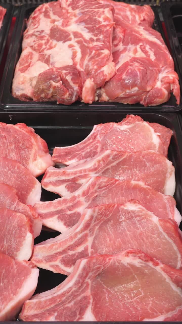 Fresh cuts of pork meat displayed in black trays, showcasing marbled textures and vibrant colors, ideal for culinary presentations and food photography