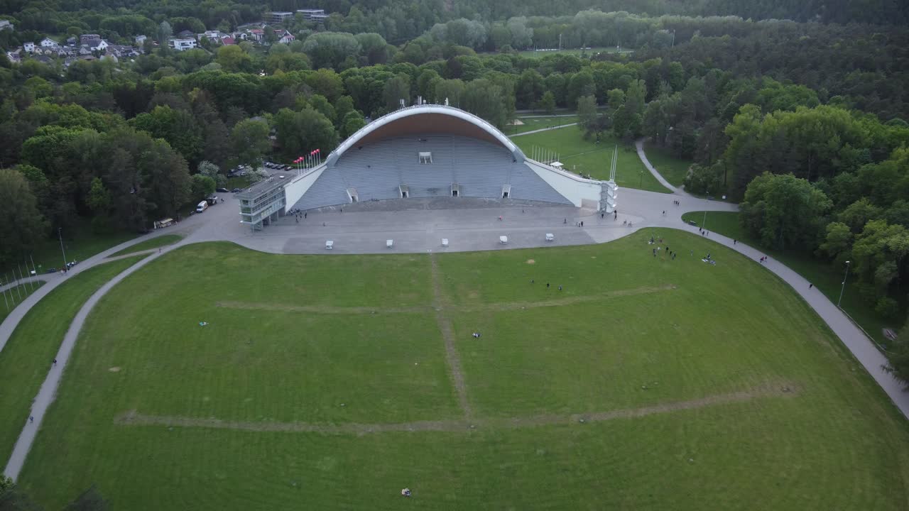 edificio de anfiteatro blanco rodeado por un parque forestal verde en vilnius, lituania