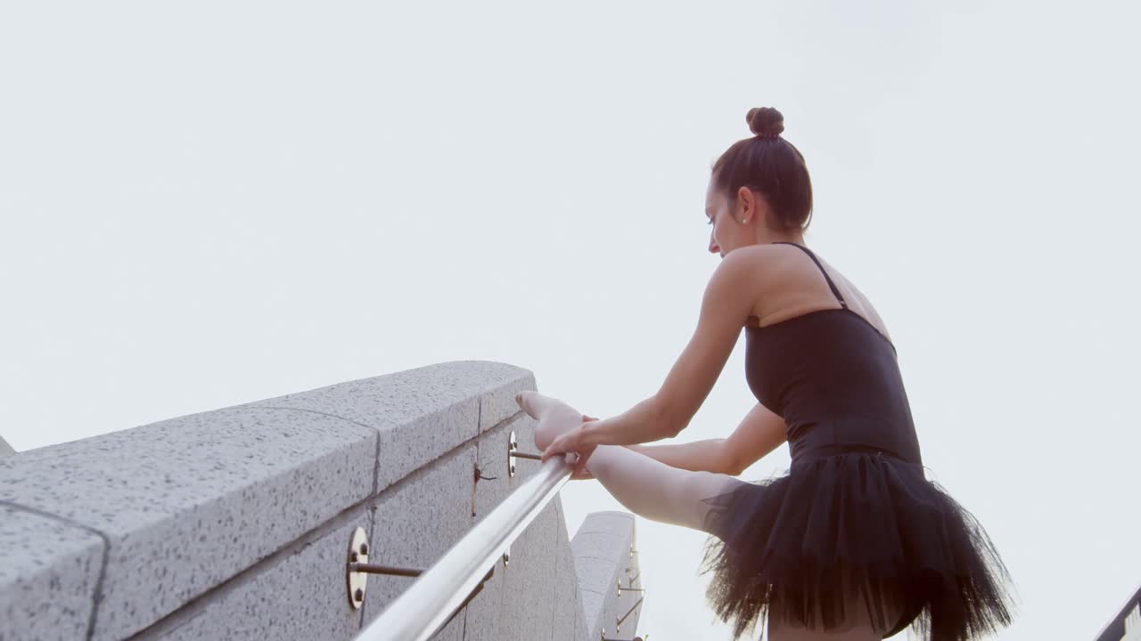 bailarina de ballet estirándose en la escalera 4k