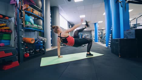 Woman doing exercises on mat. Young muscular woman doing exercise on fitness mat in the gym