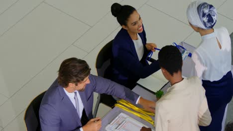 Business-people-checking-in-at-conference-registration-table-4k