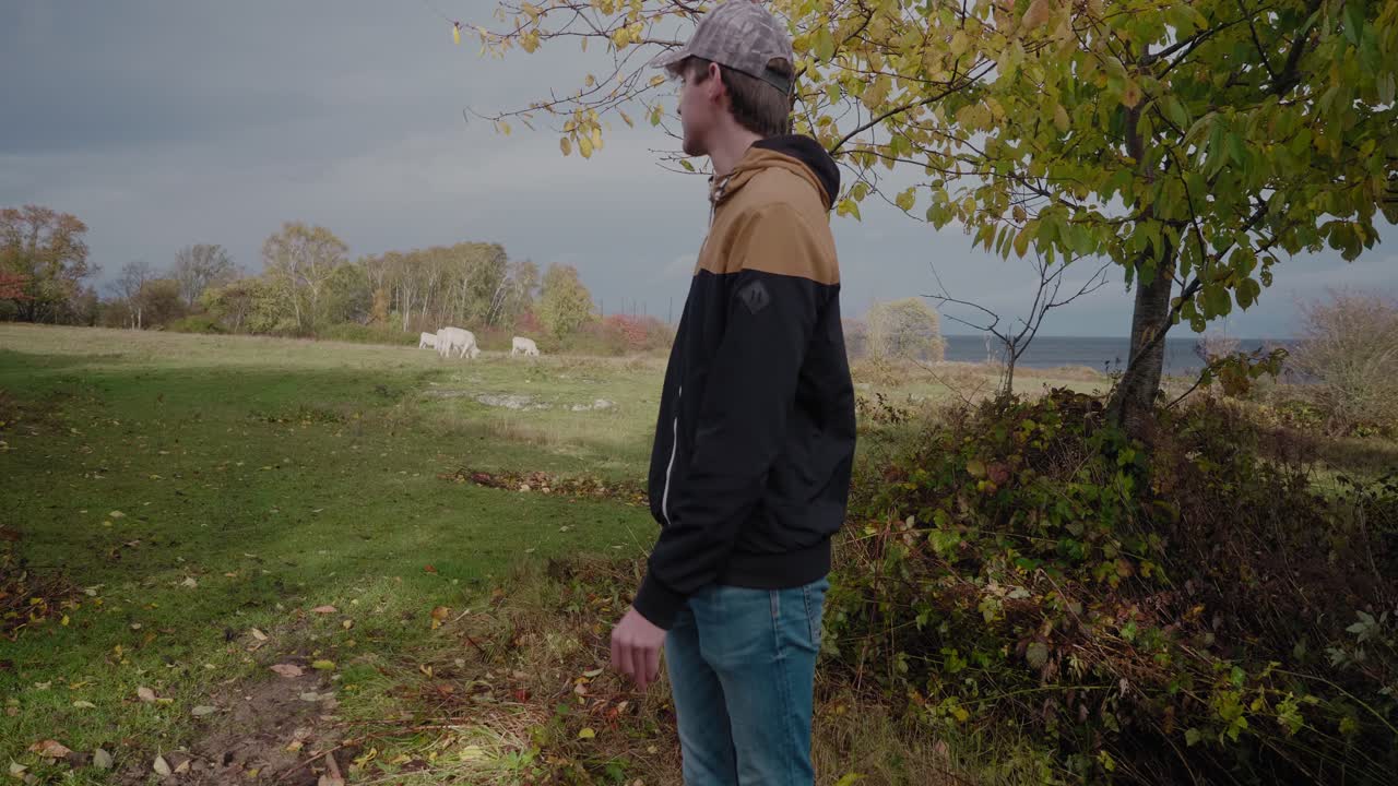 젊고 긴장된 키 큰 남자는 흰 소, skåne österlen, vårhallarna sweden과 대화할 수 있는 자신감을 수집합니다.