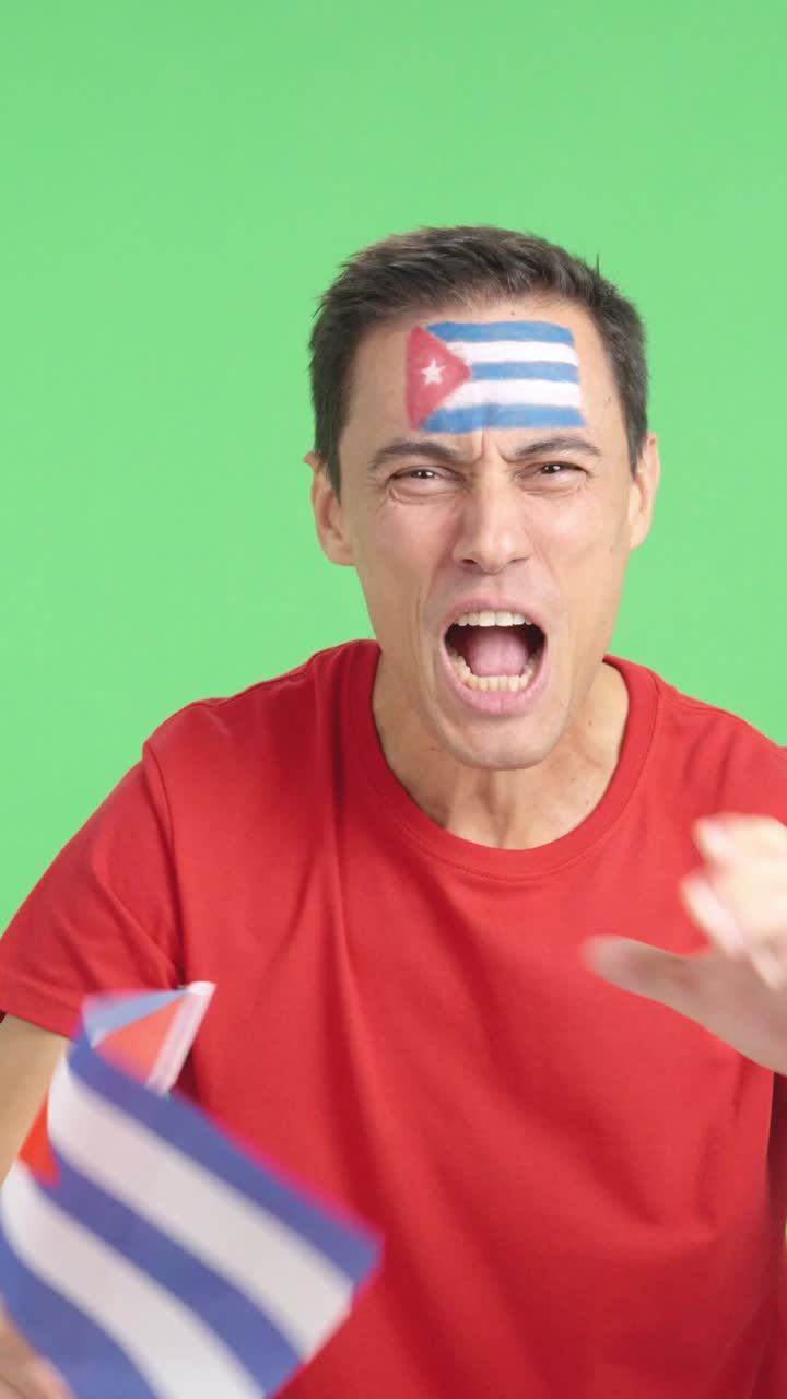 Man cheering for Cuba screaming and waving a national flag