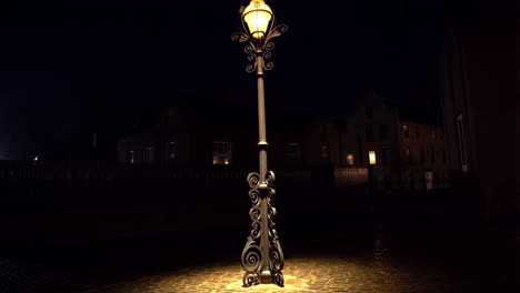 ornate street lamp illuminating a dark street at night
