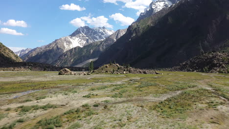 drone shot of the mountains valley and small dirt mound at naltar valley in pakistan, aerial shot