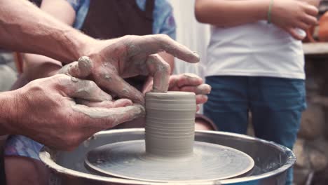 grandmother with a grandchildren make pitchers in pottery