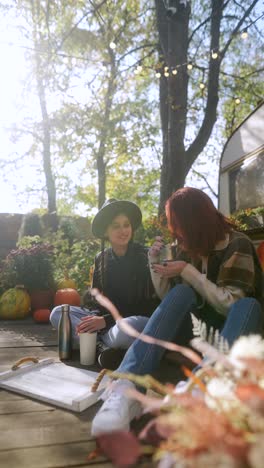 friends enjoying autumn afternoon by a campervan