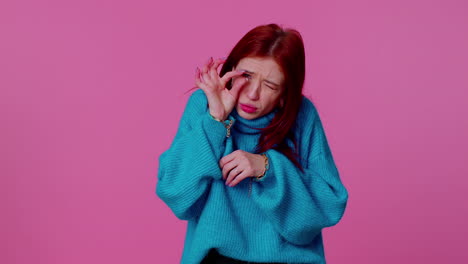 redhead cute woman in sweater showing a little bit gesture with sceptic smile, showing minimum sign