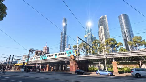 train passing through melbourne cityscape with skyscrapers