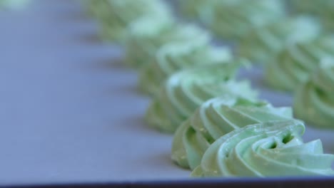 green meringues on a baking sheet