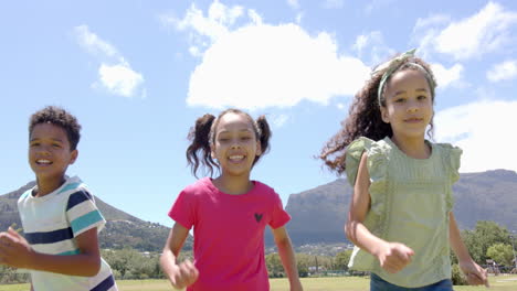 three biracial children smile and run outdoors on sunny school day