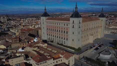 drone circling alcázar de toledo perched at top of city - spain