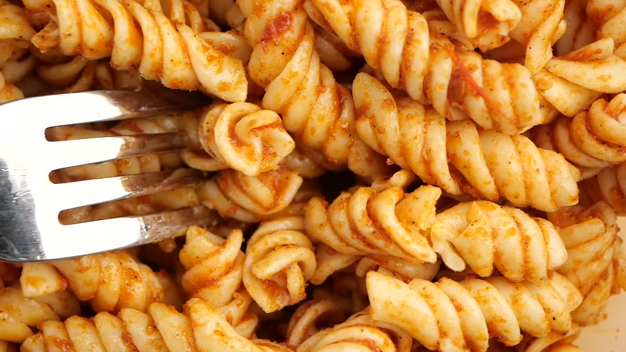 Fork Picking Up Delicious Fusilli Pasta with Sauce