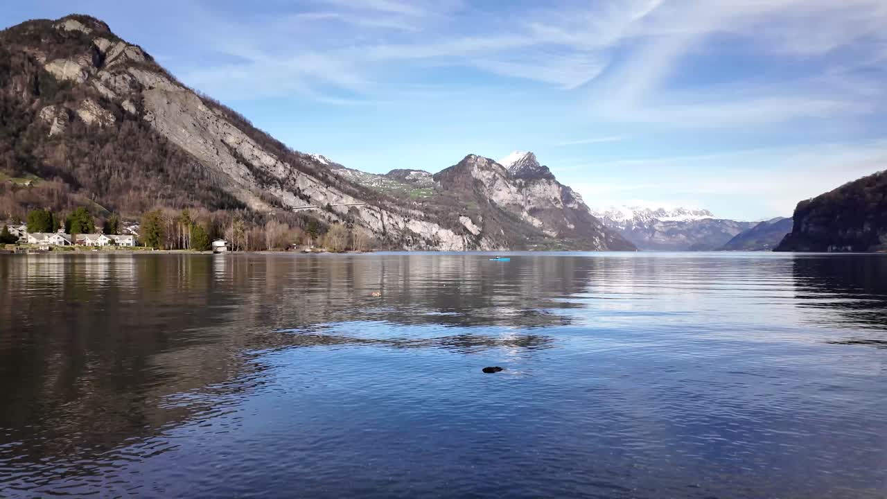 timelaps idílicos de walensee, un lago tranquilo en suiza, pequeños pueblos quinten y weesen con aguas pacíficas rodeados por la cordillera de churfirsten con los alpes suizos cubiertos de nieve en la distancia