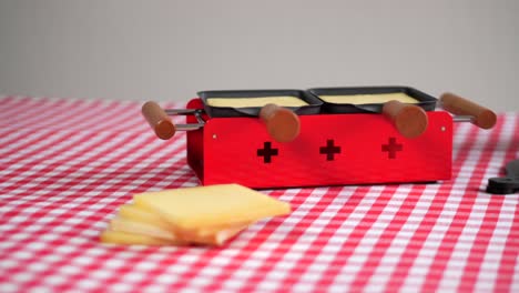 swiss cheese on red raclette oven, lateral view