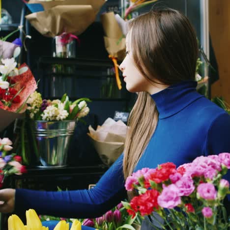 un joven florista hace un ramo en una floristería 2