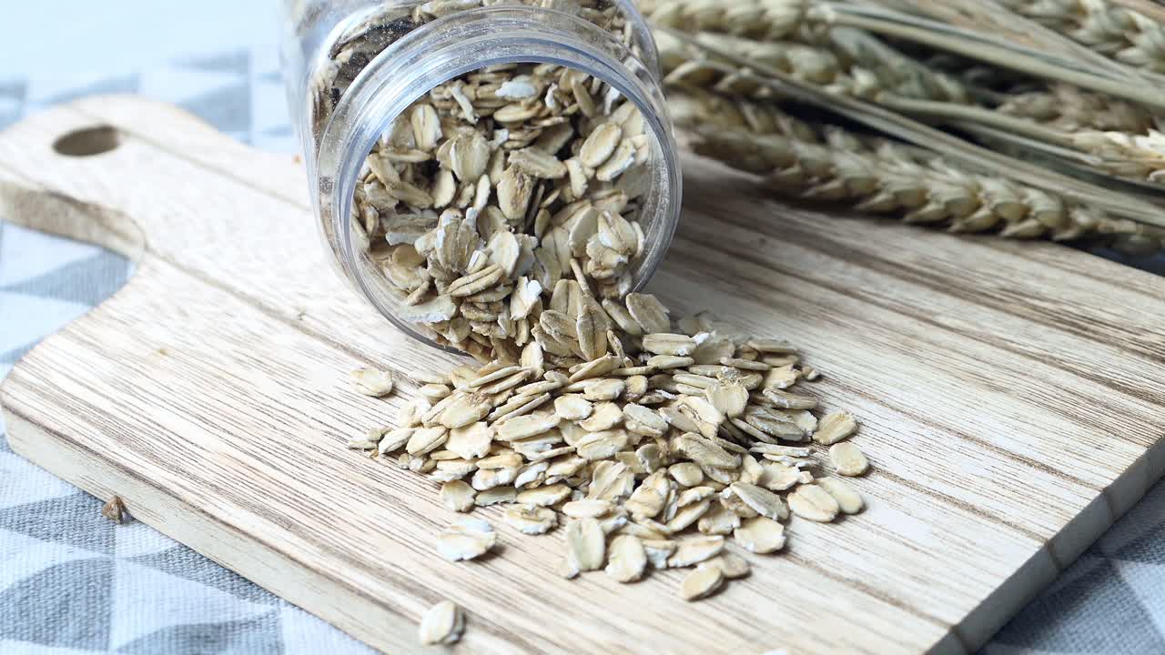 밀 이 있는 나무 절단판 위 에 있는 항아리 에 있는 오트밀