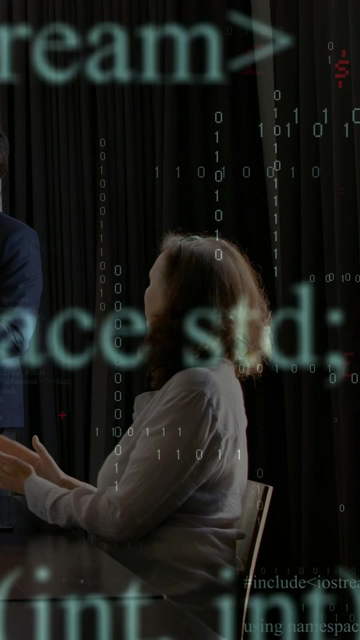 Vertical video: Seated woman answering colleague and emphasizing, initiating tech code overlays