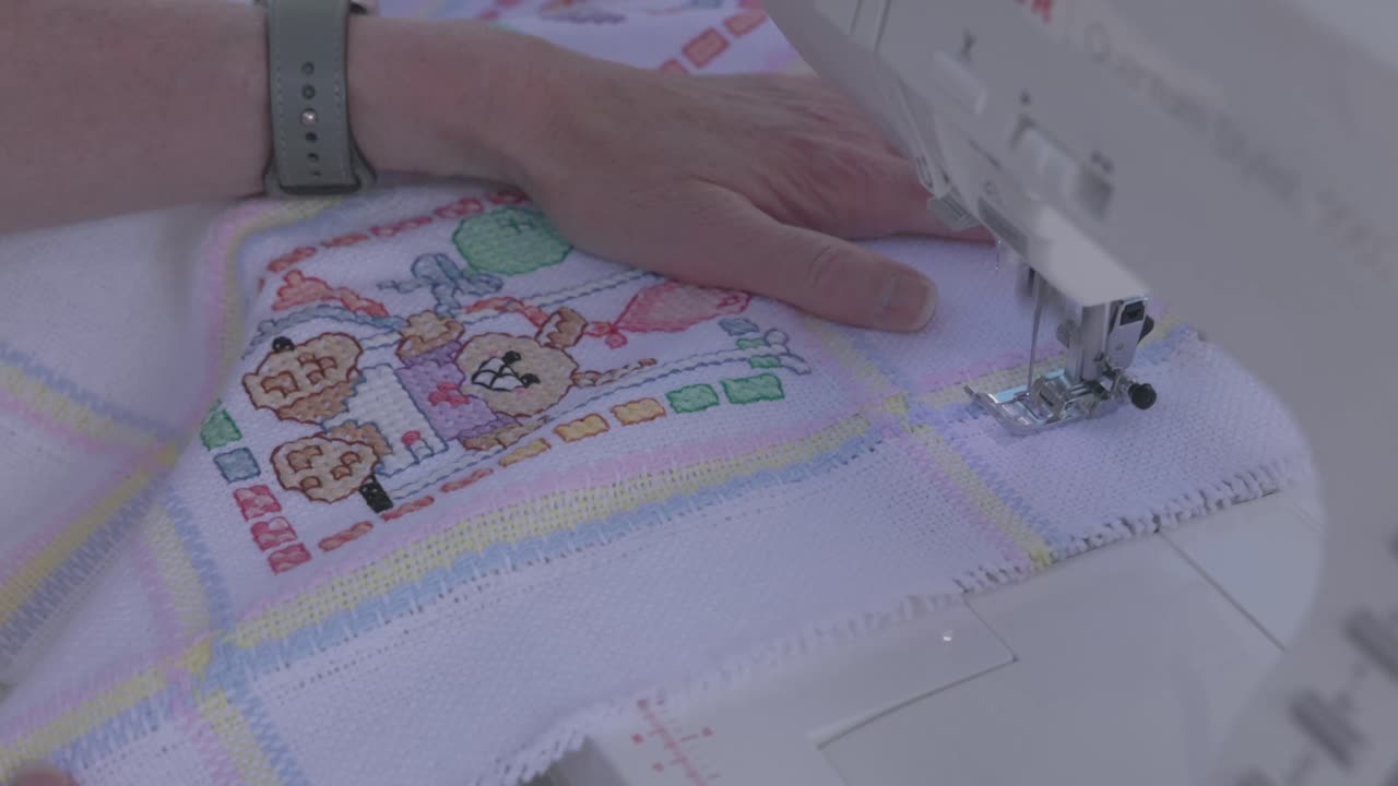 seamstress guiding a baby blanket through a electronic sewing machine