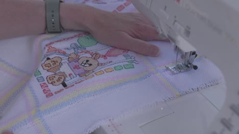 seamstress guiding a baby blanket through a electronic sewing machine