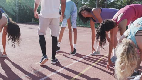 happy diverse female basketball team training with male coach on sunny court, in slow motion