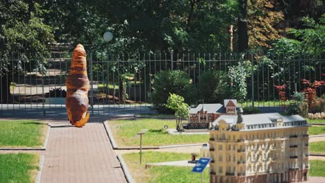 man in dinosaur costume. man wearing inflatable dinosaur costume, walking in park