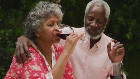 una pareja mayor afroamericana disfrutando de una copa de vino en distanciamiento social