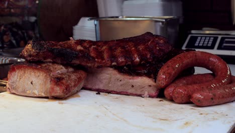 Close-up-shot-of-pork-ribs,-pork-chop-and-sausage-are-kept-over-the-tray