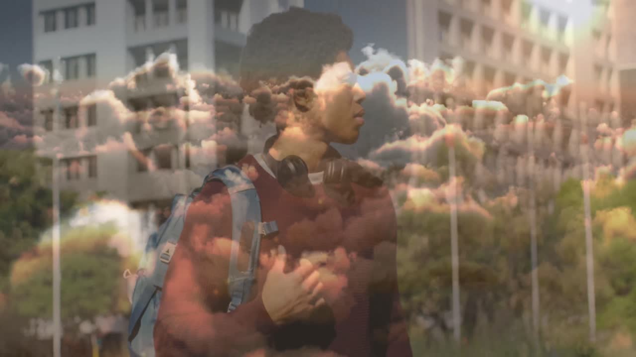 animación de nubes sobre hombre de negocios afroamericano con reloj inteligente