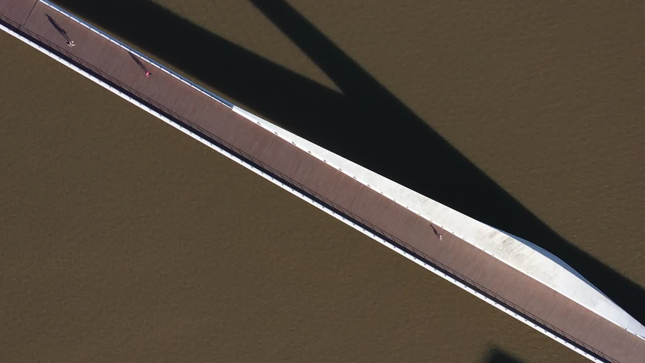 우아 한 다리 인 푸엔테 데 라 위즈레 (puente de la mujer) 의 공중 촬영, 물 위 에 긴 그림자 를 던지는, 미니멀리즘 도시 장면