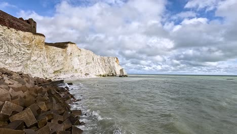 las olas golpean los acantilados en east sussex, inglaterra