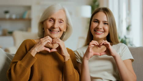 two generations of women expressing love with heart hand gestures