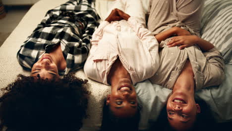 three women relaxing on a bed in pajamas