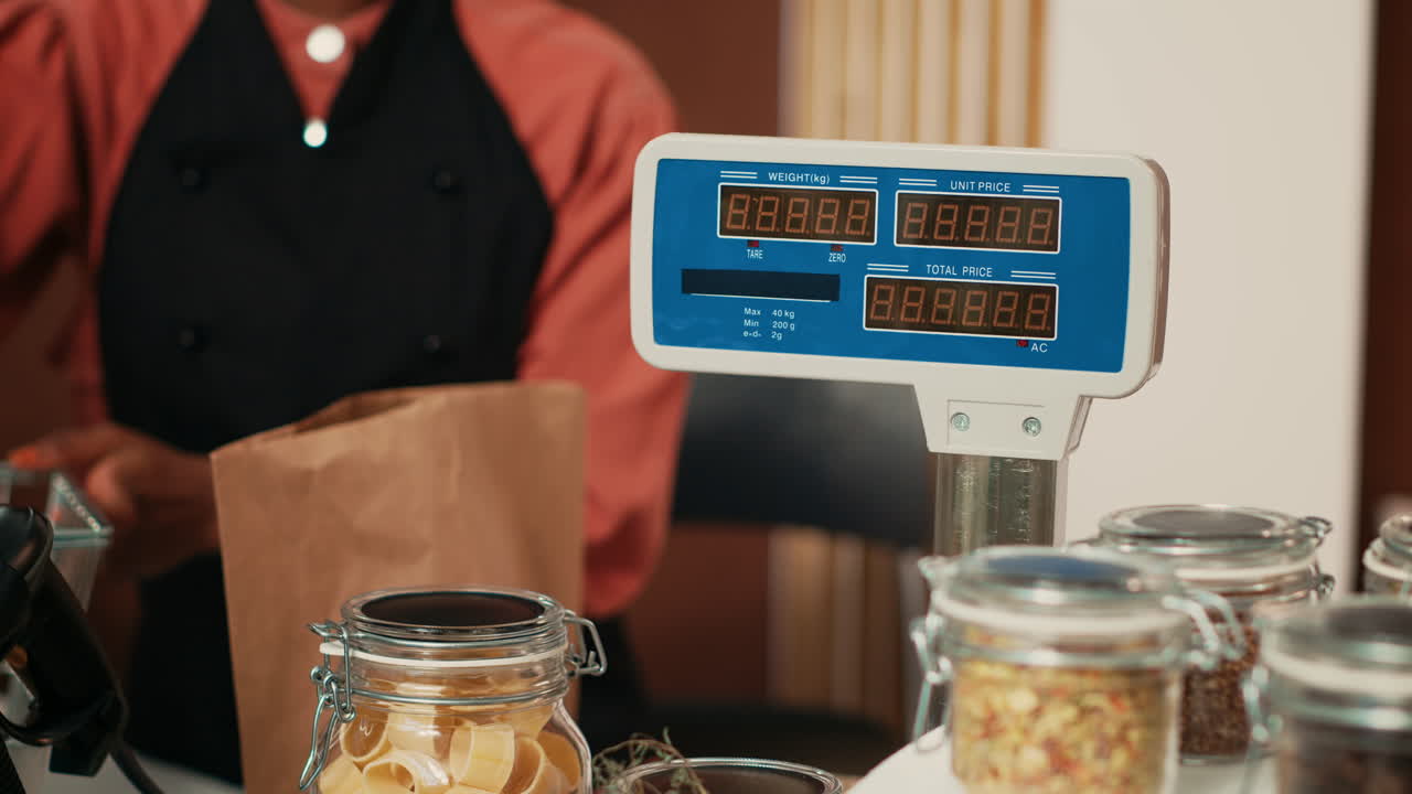 vendedor que utiliza una balanza electrónica en la caja registradora de la tienda de comestibles