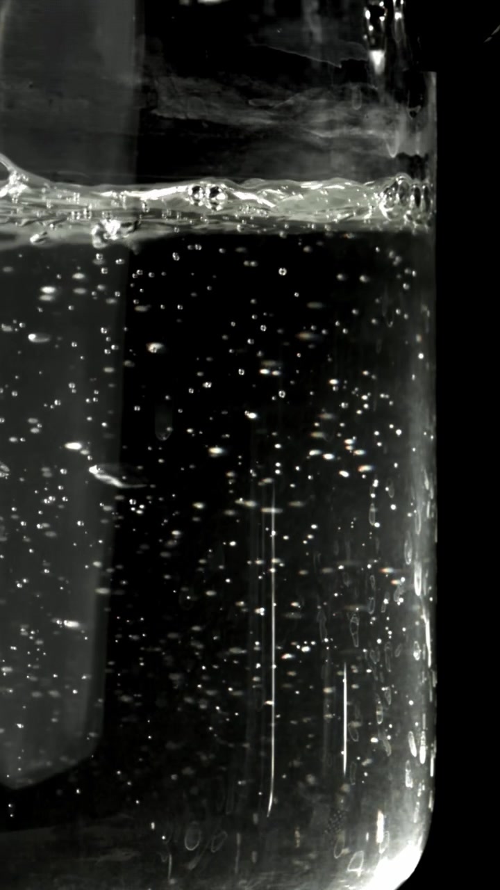 Scatto macro di bolle d'aria che salgono in acqua trasparente