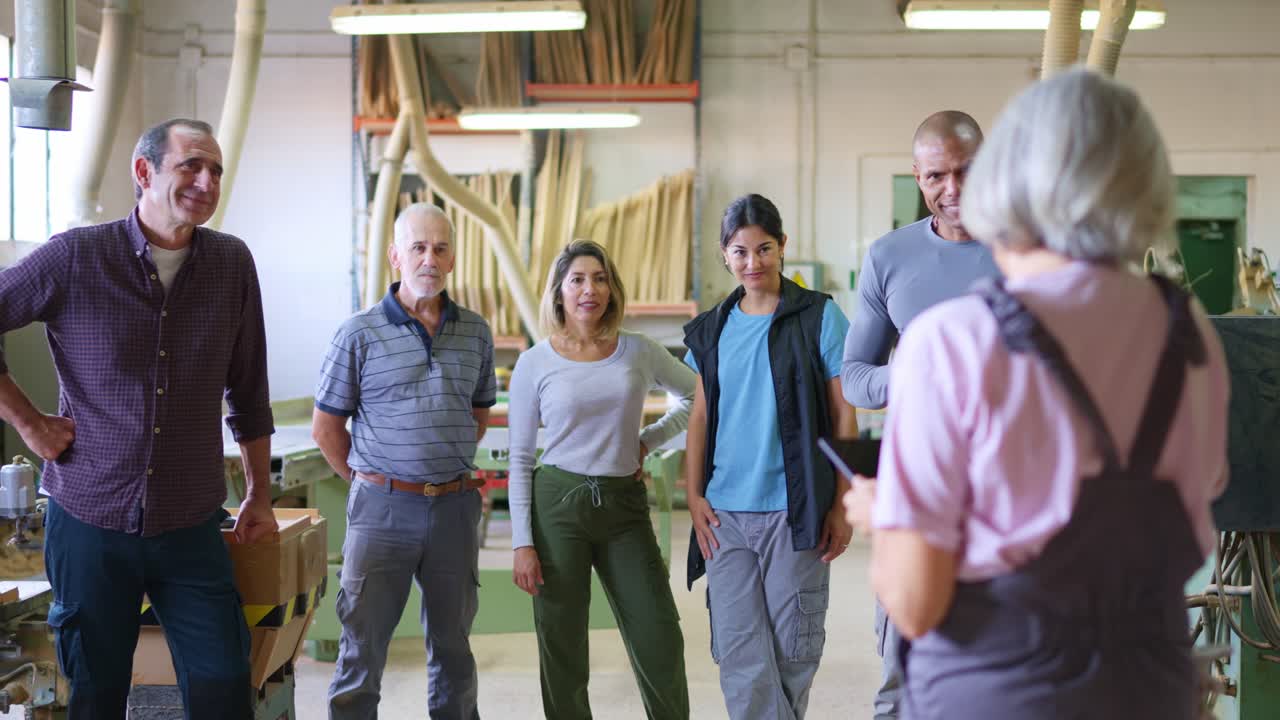 Gruppo eterogeneo di lavoratori che ascoltano le istruzioni in un workshop