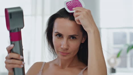 positive model drying hair smiling mirror pov portrait. girl brushing chevelure