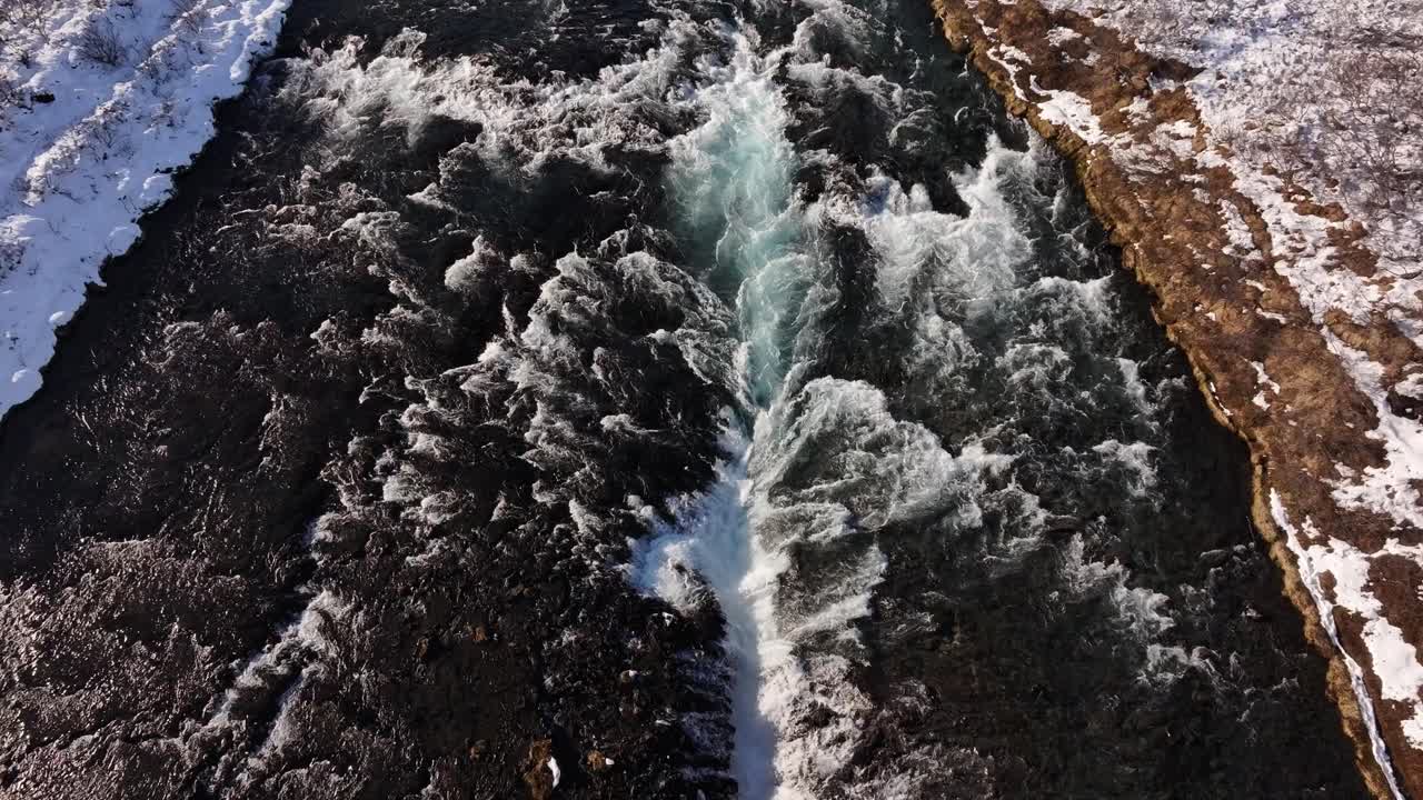 Snowy Brúarfoss waterfall with rapid streams, aerial view in Laugarvatn, Iceland