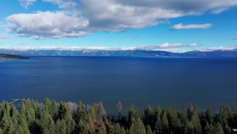 Drone-flying-over-the-trees-on-the-shoreline-of-Lake-Tahoe-on-a-sunny-day