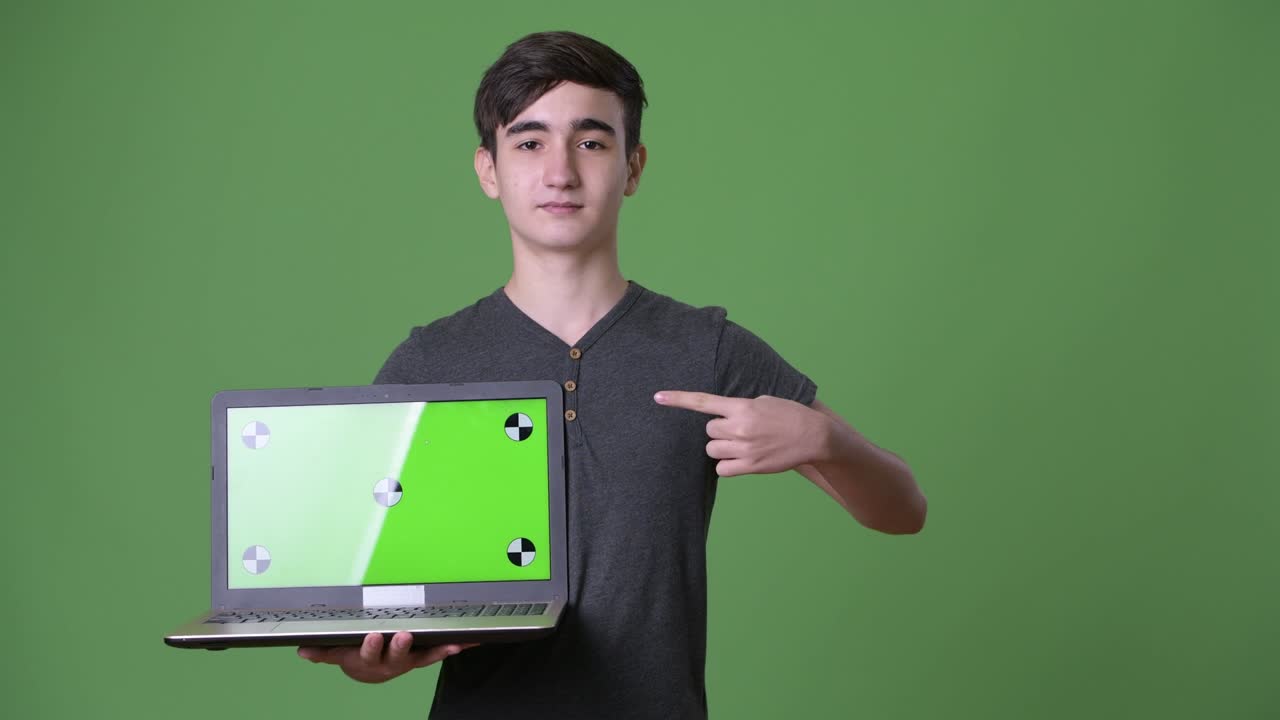 joven y guapo adolescente iraní contra un fondo verde