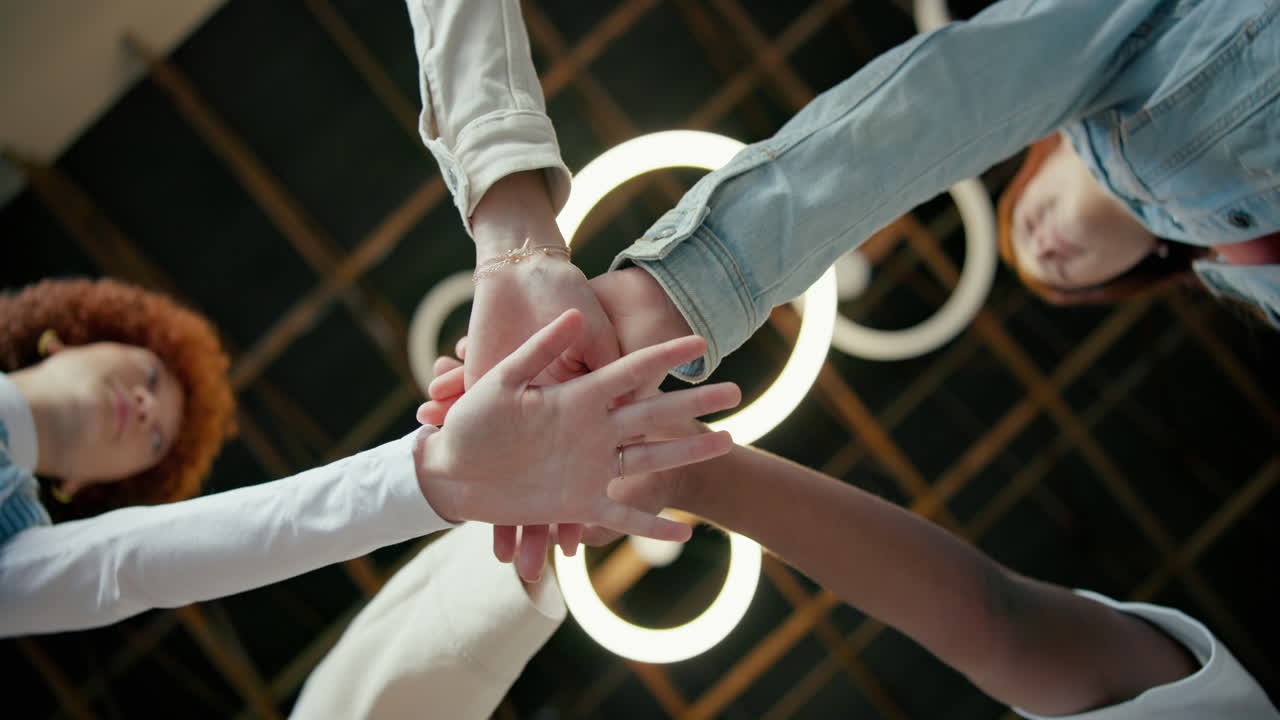 A group of diverse people putting their hands together in a show of teamwork and collaboration