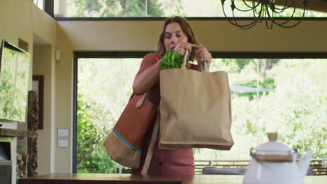 tired caucasian pregnant woman returning home from shopping with heavy bag of vegetables