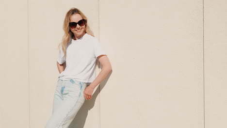 mujer en traje de moda por una pared de color beige claro