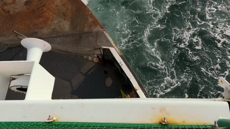 Overview-Of-Rusted-Ferry-Boat-Stern-And-Foamy-Water-Surface-While-Cruising