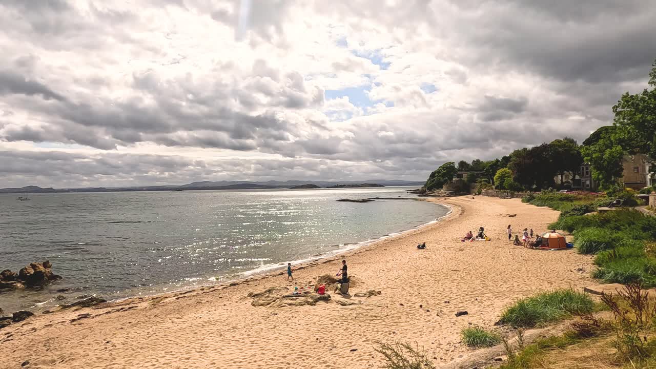 люди наслаждаются солнечным днем на пляже.